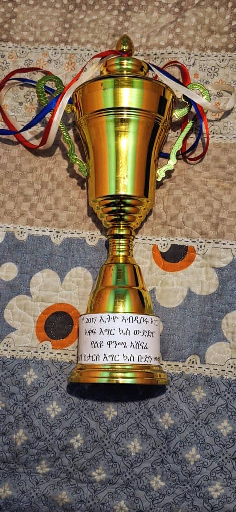 Gold football trophy with ribbons